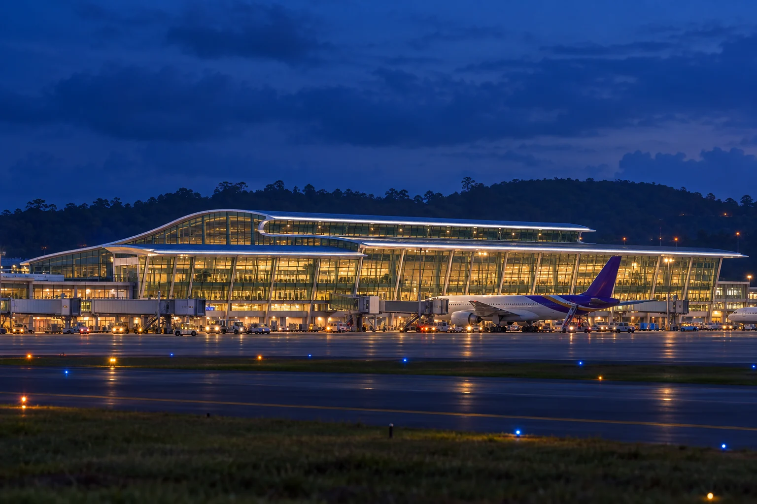 푸켓 국제공항 터미널과 항공기, 켜진 조명이 보이는 야간 재구성 이미지